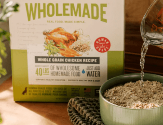 The Honest Kitchen Wholemade grain-free chicken recipe for dogs on a kitchen counter with broth and fresh ingredients
